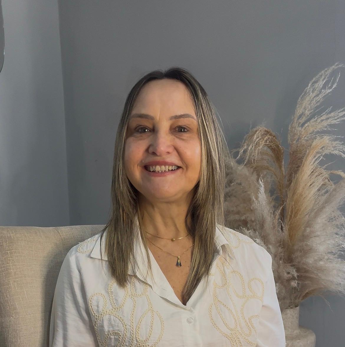 Psicopedagoga Andrea segurando materiais de alfabetização